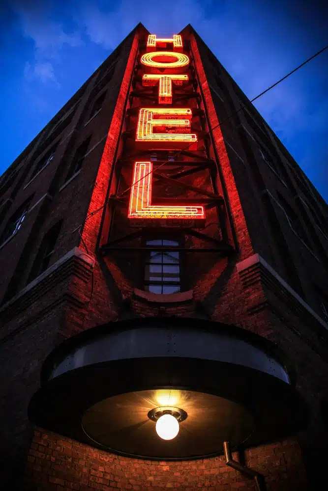 night time image of a hotel with a big red sign that says 